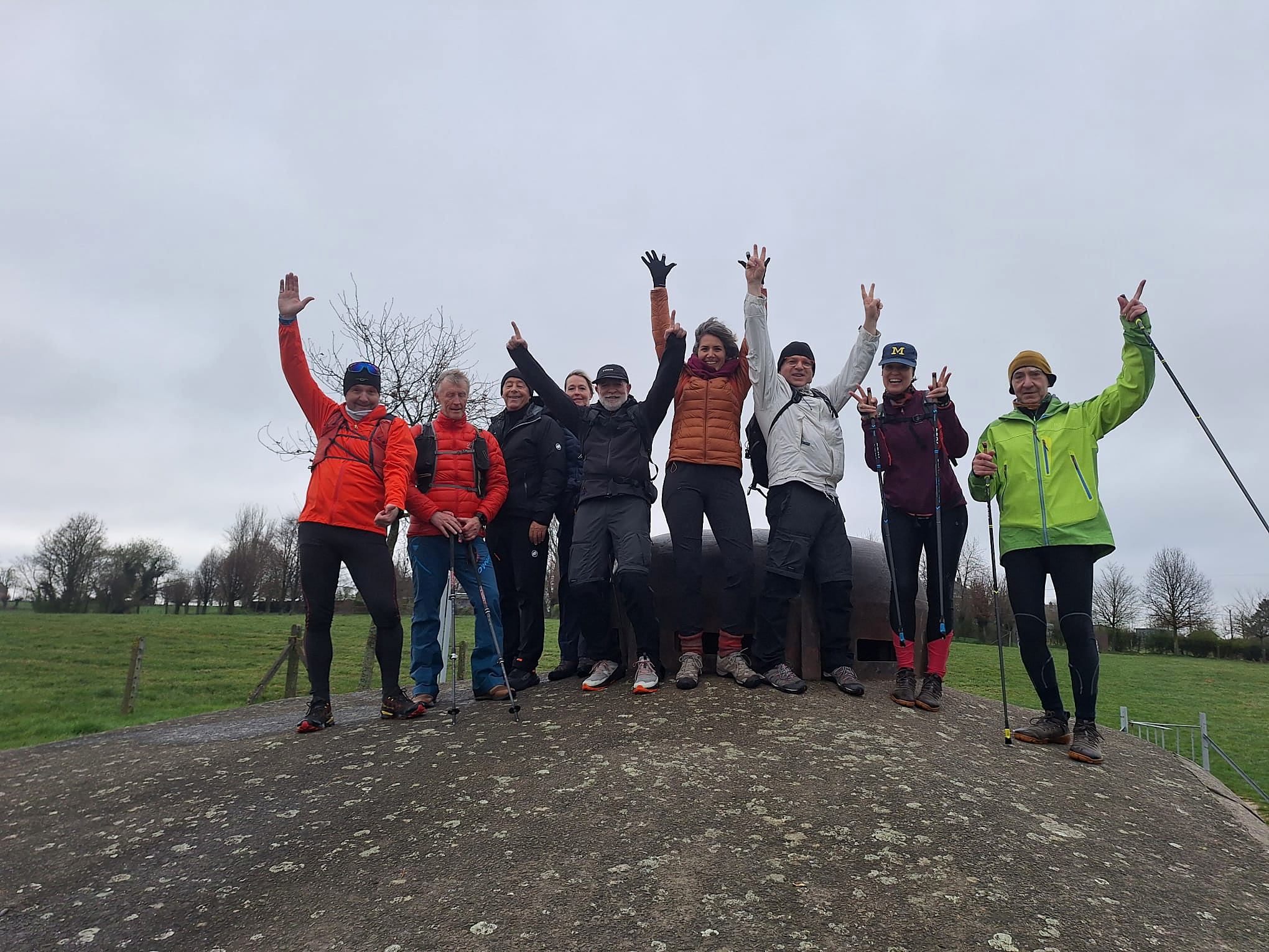 Groupe bras levés célébrant au sommet d'une colline