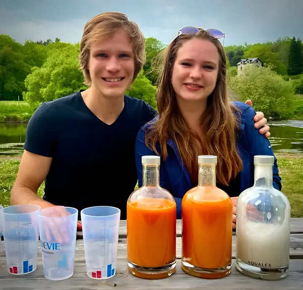 Couple souriant avec jus frais au bord de la rivière
