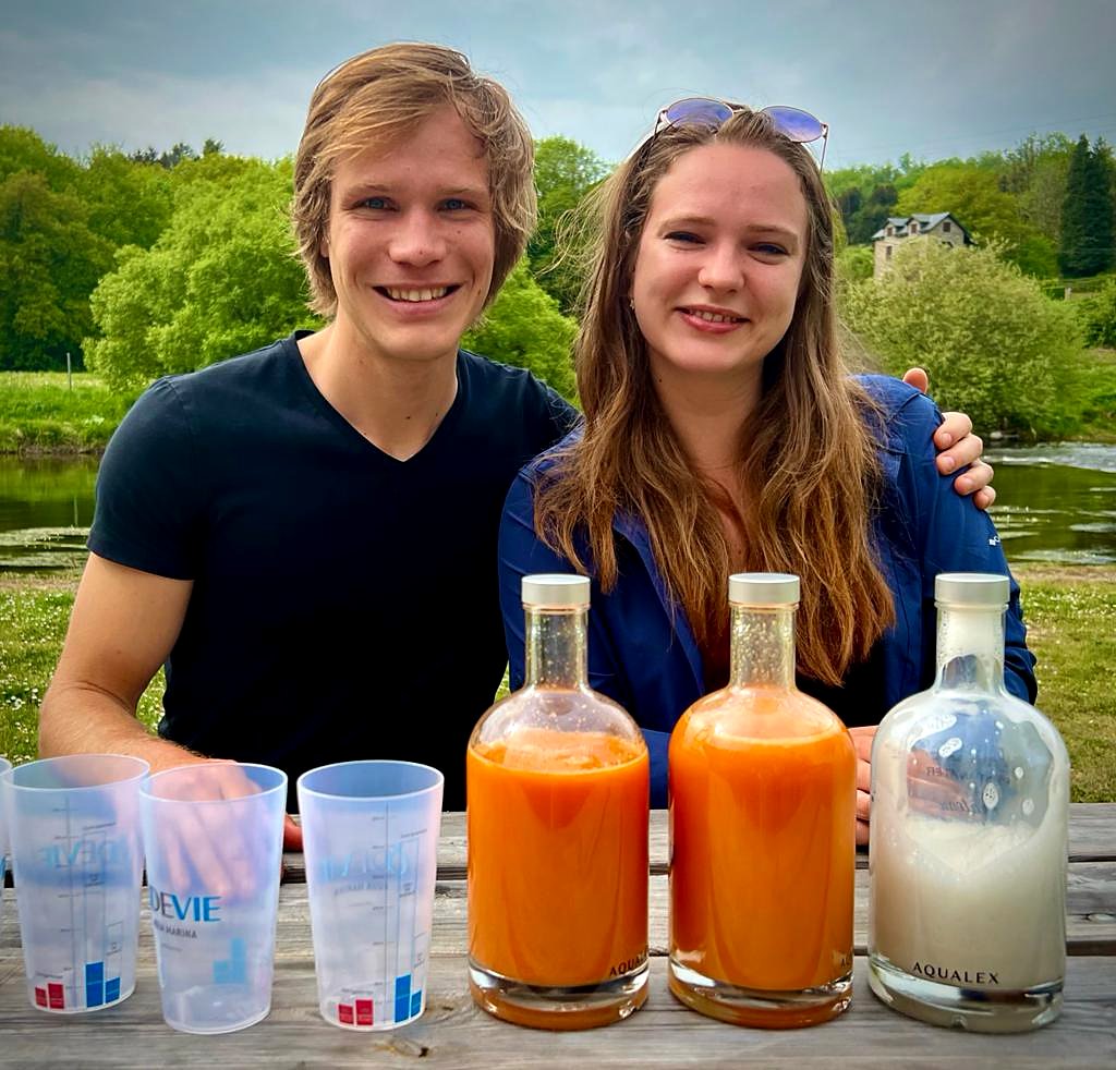 Couple souriant avec jus frais au bord de la rivière